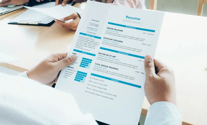 Person holding a resume at a job interview, highlighting job hunting strategies.