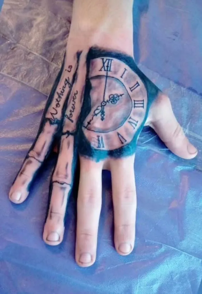 Tatuaje en mano con reloj romano y texto, ejemplo de tatuajes que fueron una mala elección y diseños poco acertados.