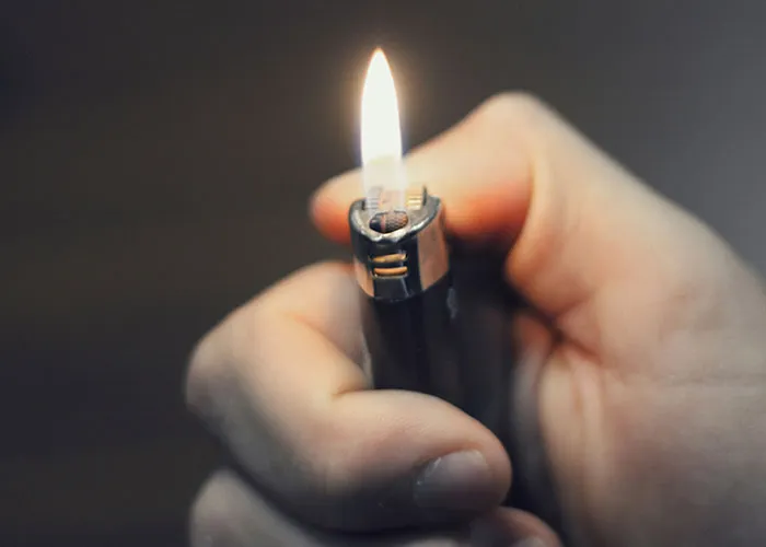Close-up of a hand holding a lit lighter symbolizing heartbroken people revealing how they realized their significant others were cheating