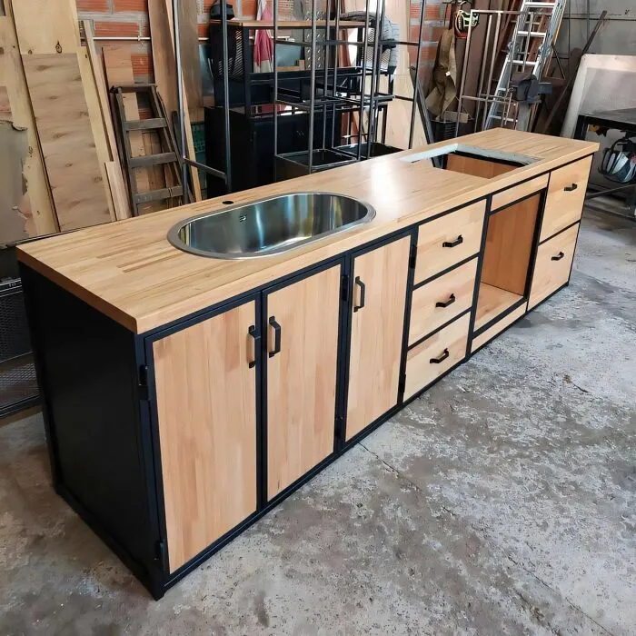 Modern woodworking ideas feature a wooden cabinet with a built-in stainless steel sink and black metal frame accents.