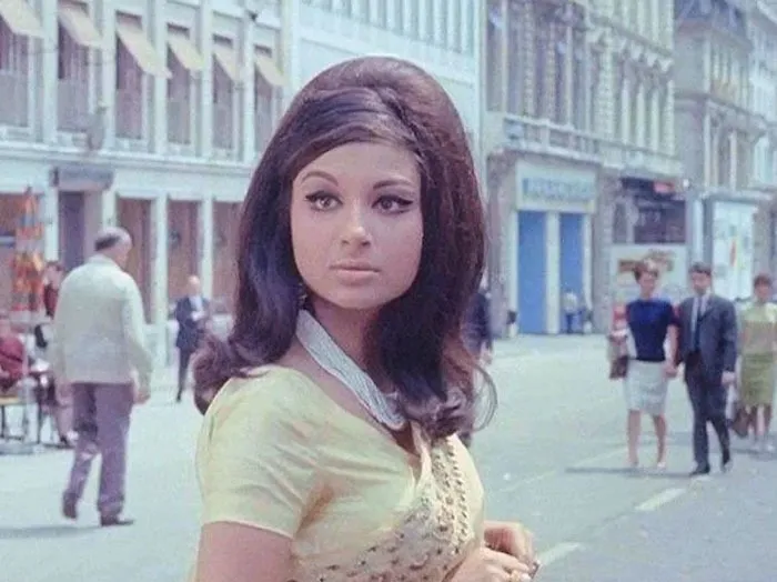 Woman with vintage hairstyle in a city street, wearing a yellow dress, illustrating amazing hairstyles from yesteryear.