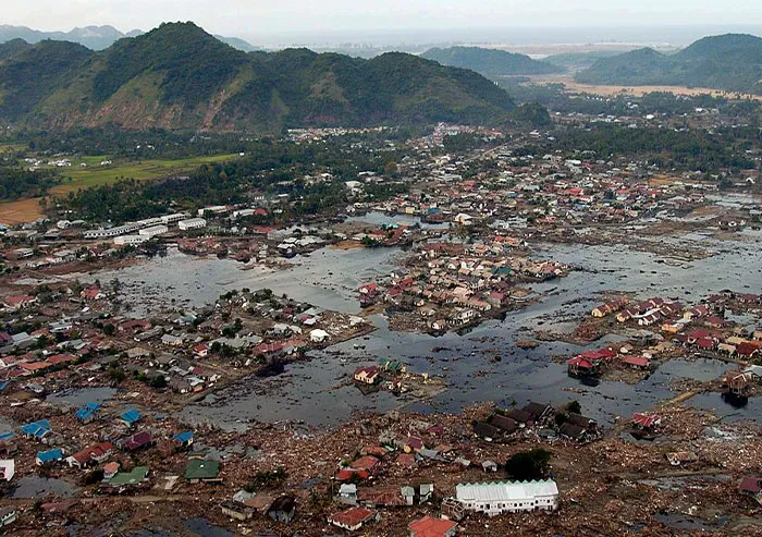 Aerial view of a flooded town with debris and destroyed buildings, showing a significant moment in history.