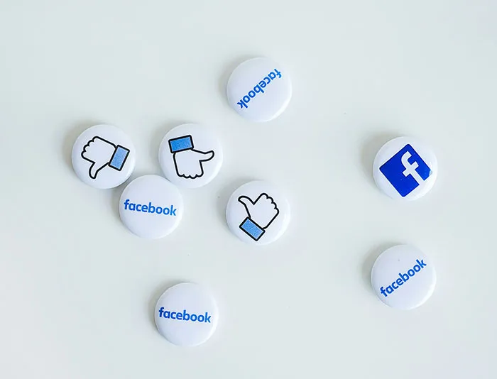 White buttons with Facebook logo and like, thumbs up and thumbs down icons representing moments in history importance.