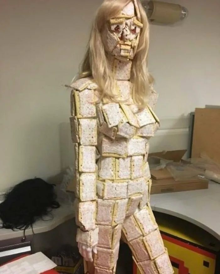 Figura humana cubierta con imágenes malditas de pastelillos que no se pueden explicar en un ambiente de oficina.