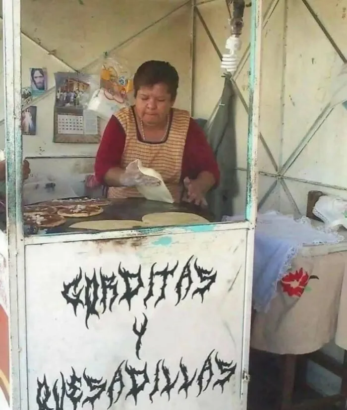 Mujer preparando quesadillas en un puesto con cartel de “Caqditas y Quesadillas” en imagen maldita inexplicable.