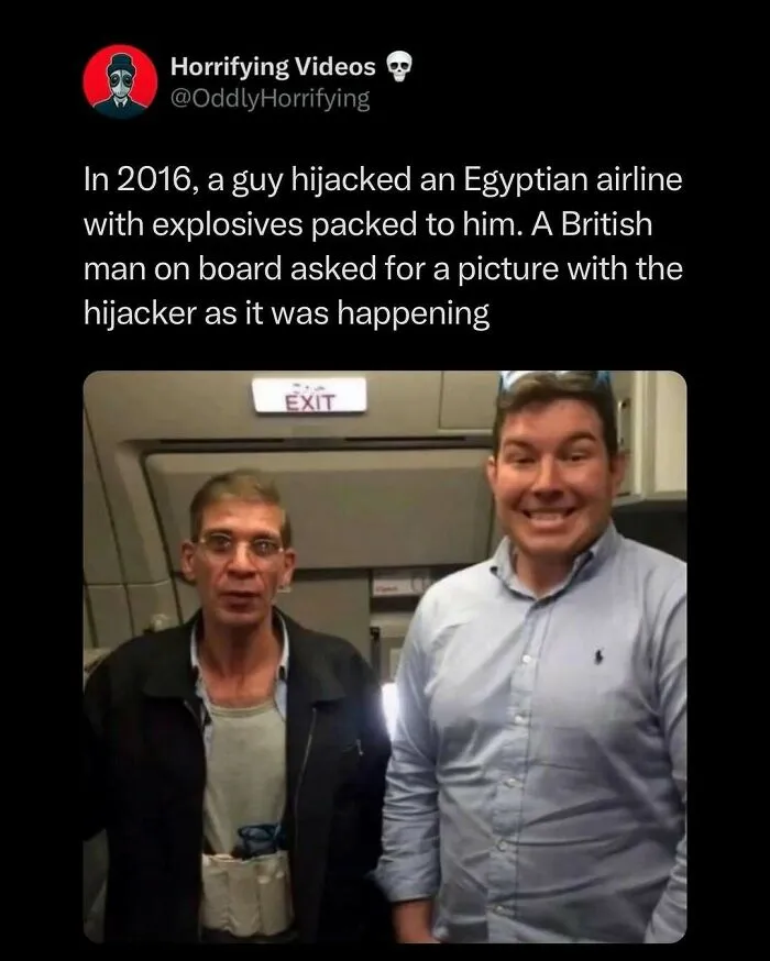 Two men on an airplane, one looking tense, the other smiling. The unnerving image captures an oddly horrifying moment.