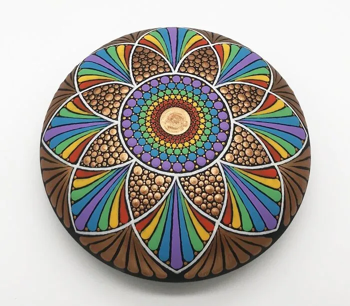 Colorful mandala art intricately painted on a stone, showcasing a mesmerizing design with vibrant patterns.