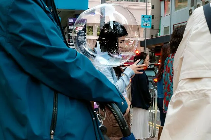 A perfectly timed photo by Edas Wong shows a person’s head aligned with a transparent balloon, creating a surreal effect.
