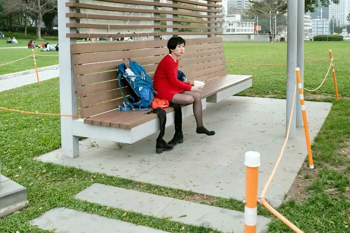 Person on a bench in a red outfit, with perfectly timed lines creating a visually interesting scene.