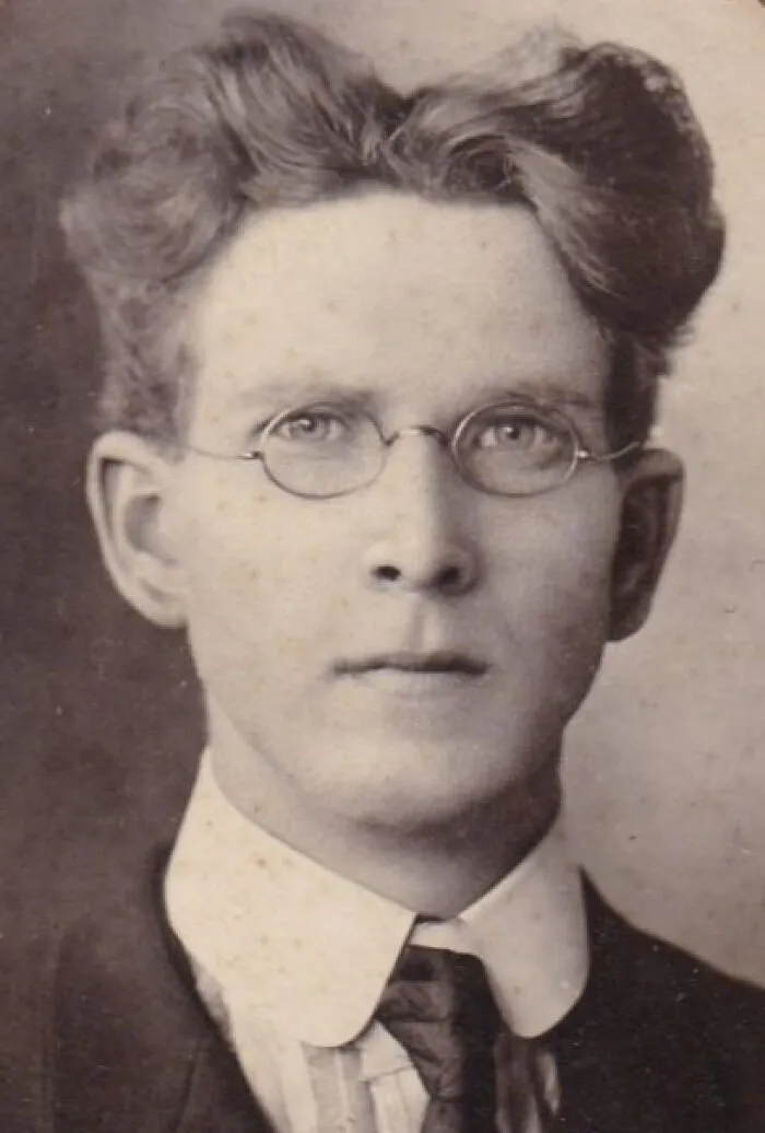 Vintage photo of a man with an unusual hairstyle, wearing glasses, showcasing retro hair fashion.