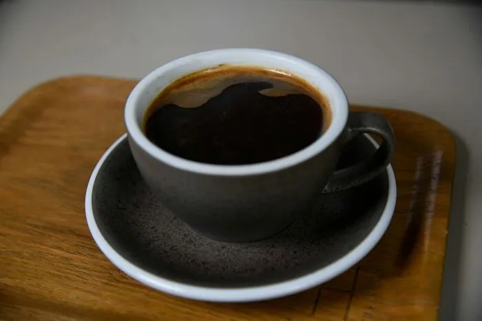 Coffee cup on a wooden tray, suggesting a break to manage difficult coworkers.