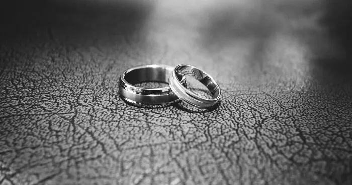 Two silver rings on a textured surface, highlighting unpopular opinions on traditional marriage.