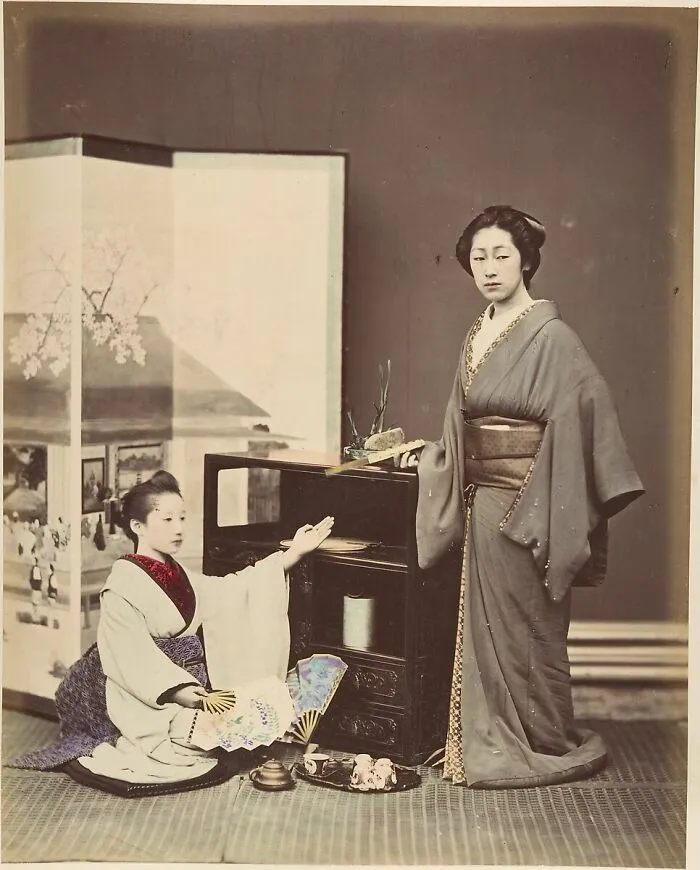 Two Japanese Women Posing With Fans