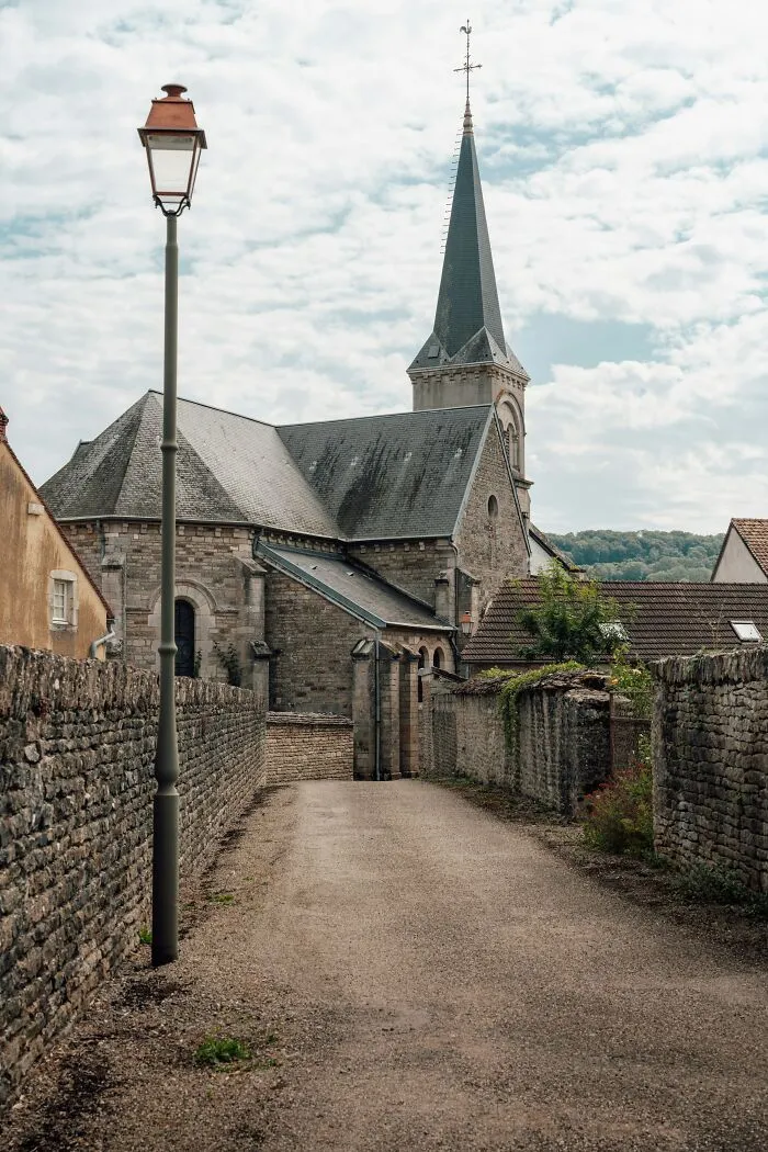 Rustic street with church, featuring an oddly positioned lamppost, suggesting a glitch in the matrix.