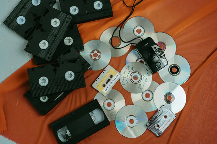 Vintage items, including VHS tapes and CDs, placed on an orange cloth, representing things Boomers might be right about.