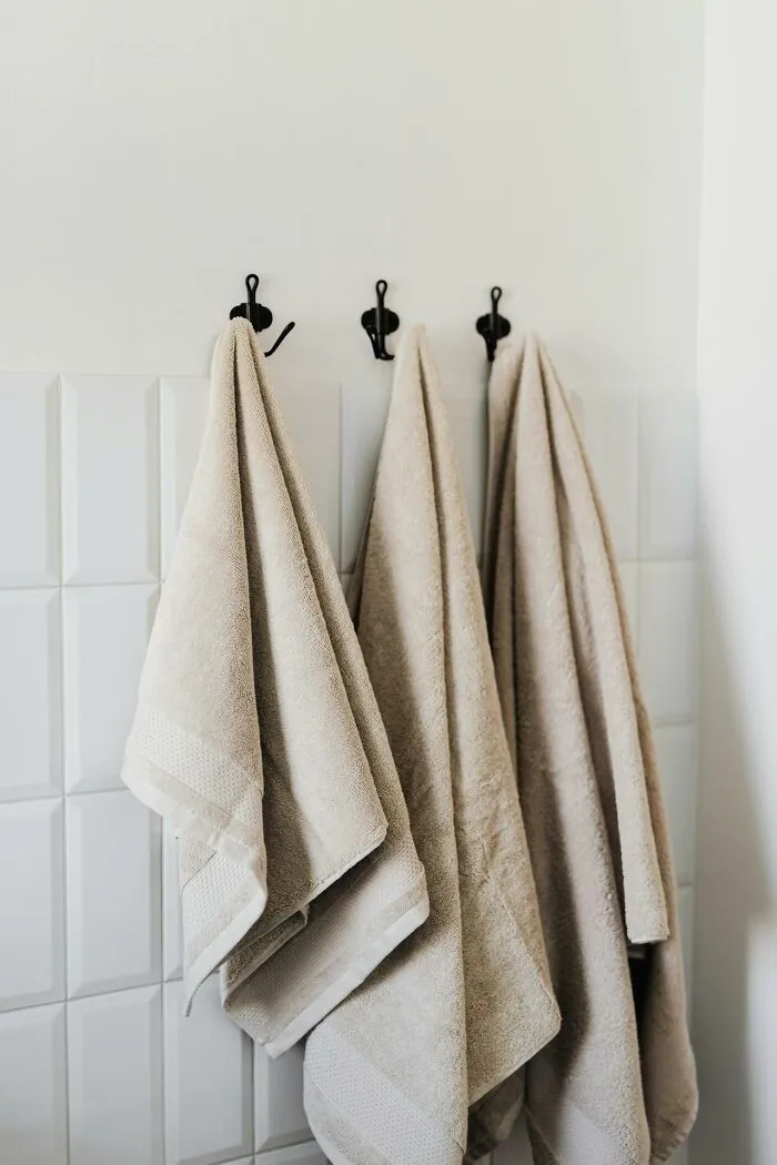 Towels neatly hanging on hooks, illustrating cleaning rules preferences.