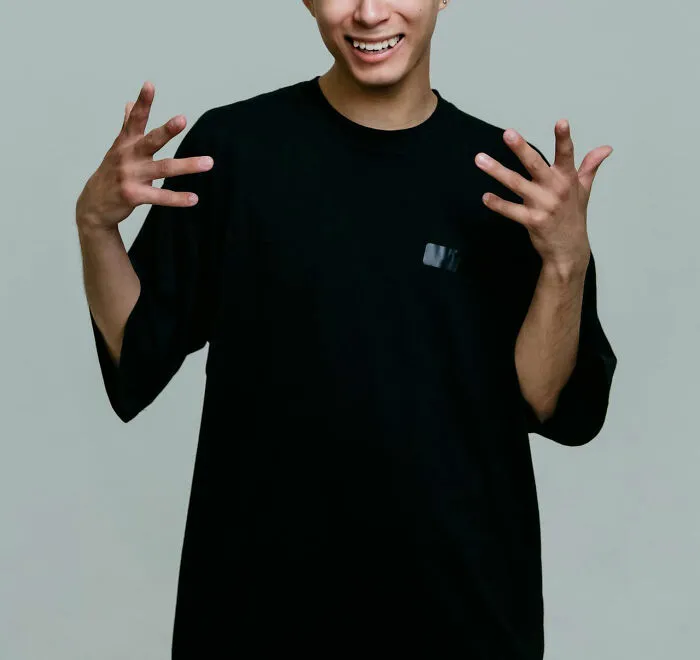 A person in a black shirt smiling with open hands, discussing disturbing medical cases.