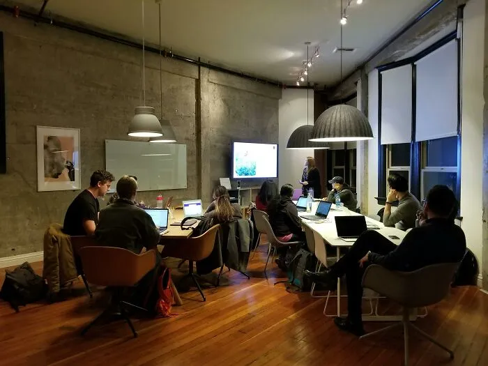 Team meeting in a modern office, people with laptops facing a presenter, highlighting biggest red flag job interview signs.