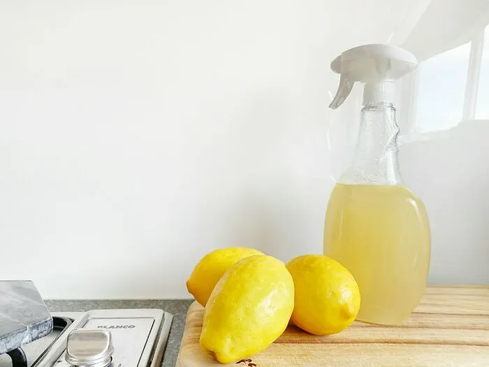 Lemons and homemade cleaner on a kitchen counter representing cleaning rules.