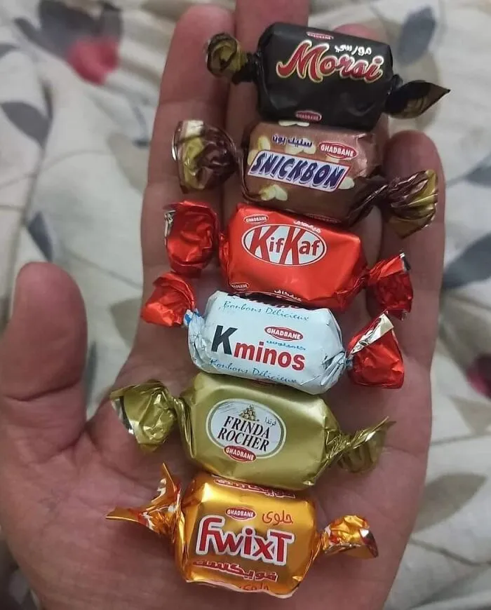 Assorted random candies in hand, including unique twists on popular chocolate brands.