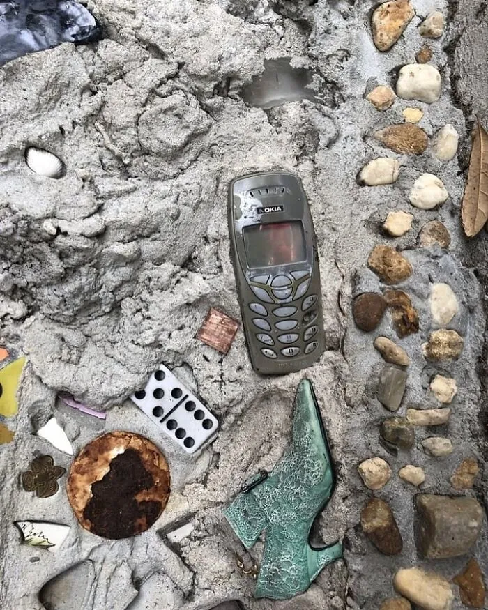 Random cool objects like a vintage phone, green shoe, domino, and stones in concrete for a touch of joy.