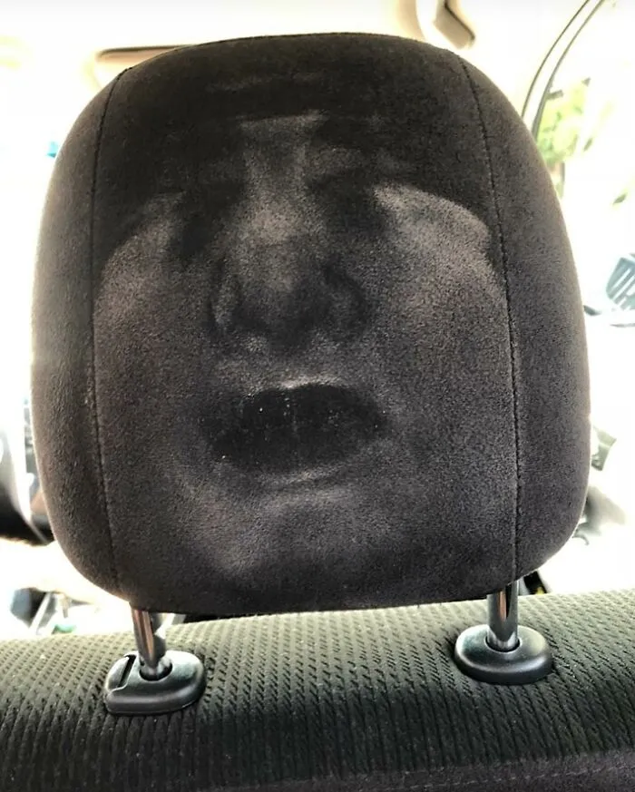 Dusty car seat headrest with a face imprint, creating a cool and random shadow effect.