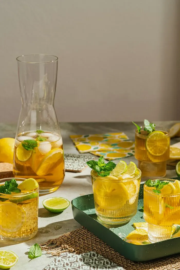 Iced lemon and mint drinks served in glasses and a carafe, showcasing refreshing restaurant food beverages on a table.