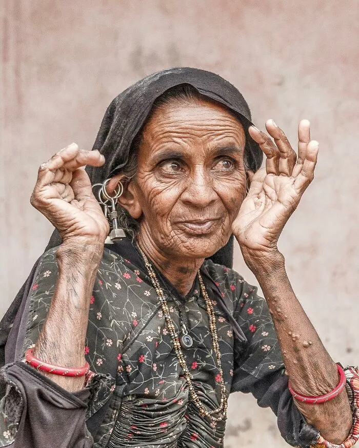 Retrato elocuente de mujer mayor con arrugas y vestimenta tradicional, parte de retratos de personas mayores en el mundo.