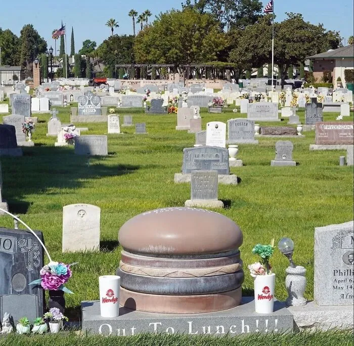 Graveyard with a tombstone shaped like a hamburger and cups, an uncomfortable image for no apparent reason.