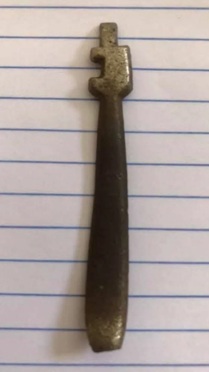 Old rusty key with unusual shape found among strange things in homes with hidden and forgotten pasts.