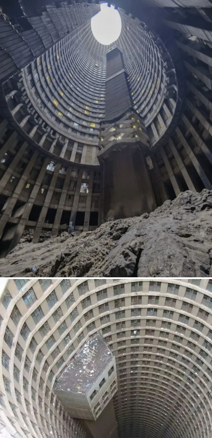 Massive circular building interior with towering walls and a large rocky floor creating a megalophobia fear of big spaces.