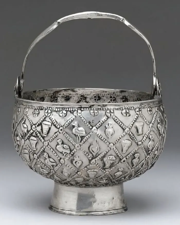 Ancient silver bucket with intricate engraved patterns and animal motifs, showcasing archaeology news and architecture details.