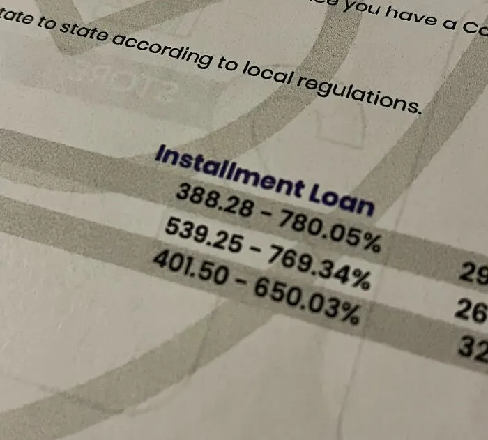 Close-up of an installment loan document showing high interest rates, reflecting challenges in current life in the US.