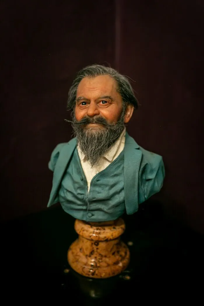 Highly realistic sculpture bust by Ruben Orozco Loza showing an elderly man with detailed facial features and clothing.