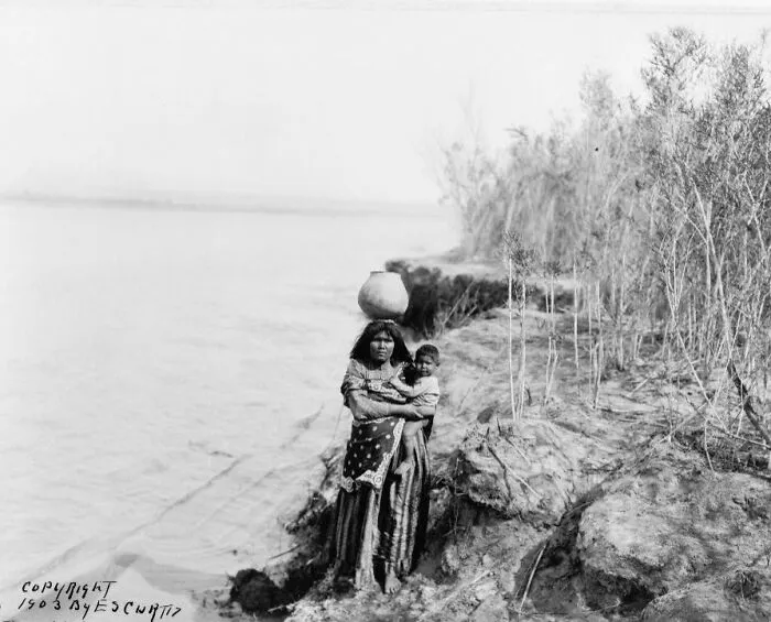 Mohave Woman Carrying Water On Her Head And Holding Child
