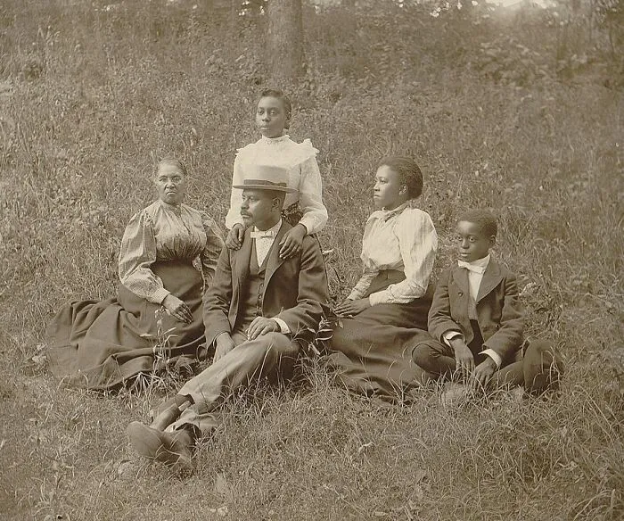 A Family Posed For Portrait Seated On Lawn