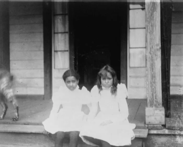 Two Girls Sitting On A Porch