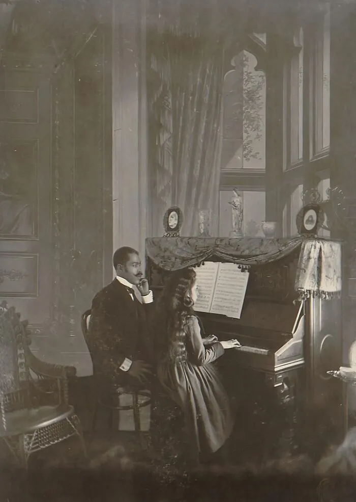 A Man Giving Piano Lesson To A Young Girl