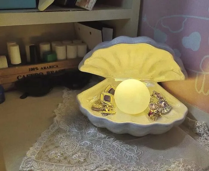 Bring Some Under-The-Sea Magic To Your Nightstand With A Glowy <a Style="Display:inline;" Href="Https://Www.amazon.com/Dp/B08zkrj6r9?ascsubtag=7868796%2c23%2c35%2cd%2c0%2c0%2c0%2c1396%3a1%3b900%3a2%3b974%3a1%3b1338%3a1%2c62105307%2c0%2c0%2cgoogle&btn_ref=srctok-8b9d9128365658a7&th=1&linkcode=ll1&tag=bporange-20&linkid=7d66efd51599109944c9b18e652ac136&language=en_us&ref_=as_li_ss_tl" Target="_blank"><span Style="Font: Inherit; Color: #d74b1f;"> Clam Shell With Pearl Nightlight </Span