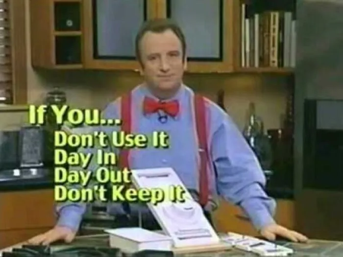 Man wearing a red bow tie and suspenders in a kitchen with text about not keeping unused items, showing cringey nineties fashions.