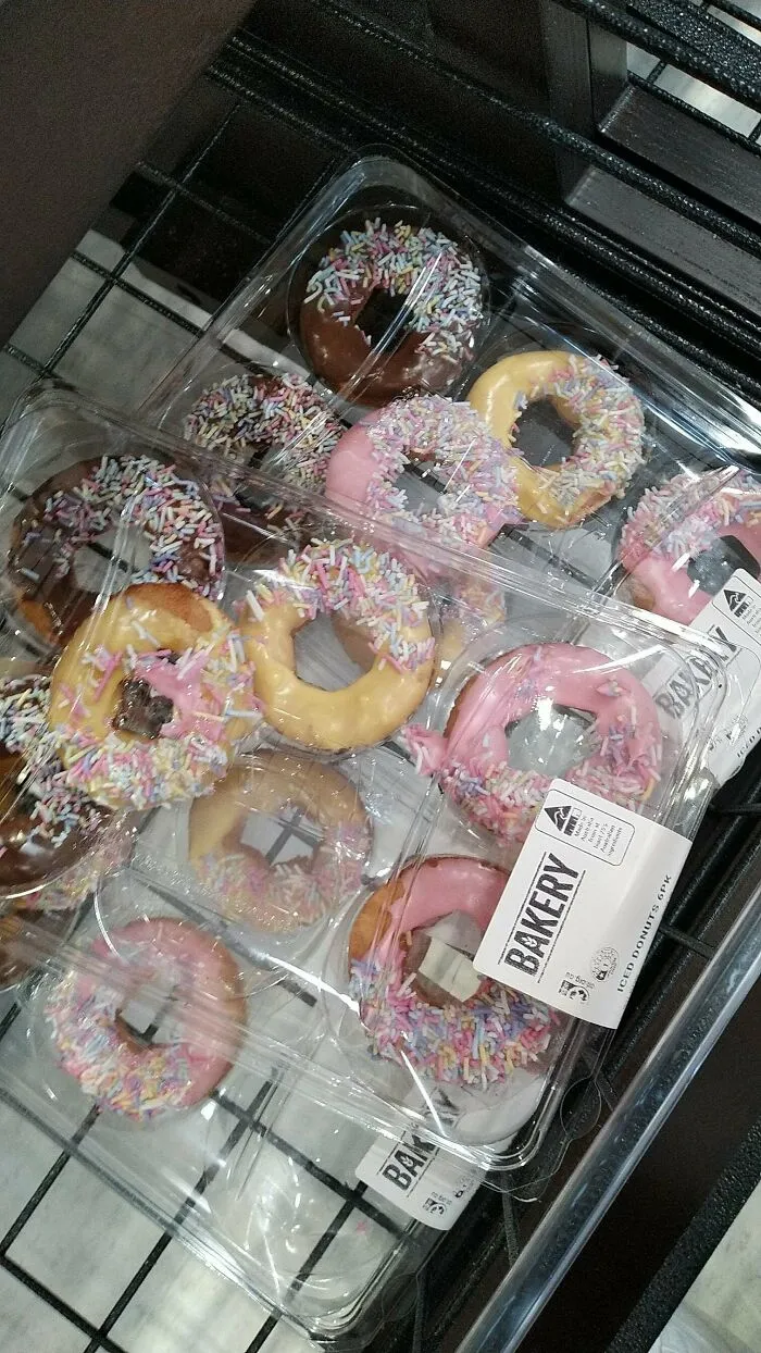 Clear plastic packs of small iced donuts with colorful sprinkles, illustrating products getting smaller and more expensive.