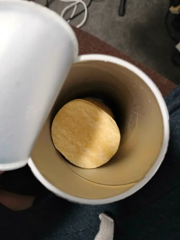 Stack of fewer and smaller potato chips inside a can, illustrating products getting smaller and more expensive.