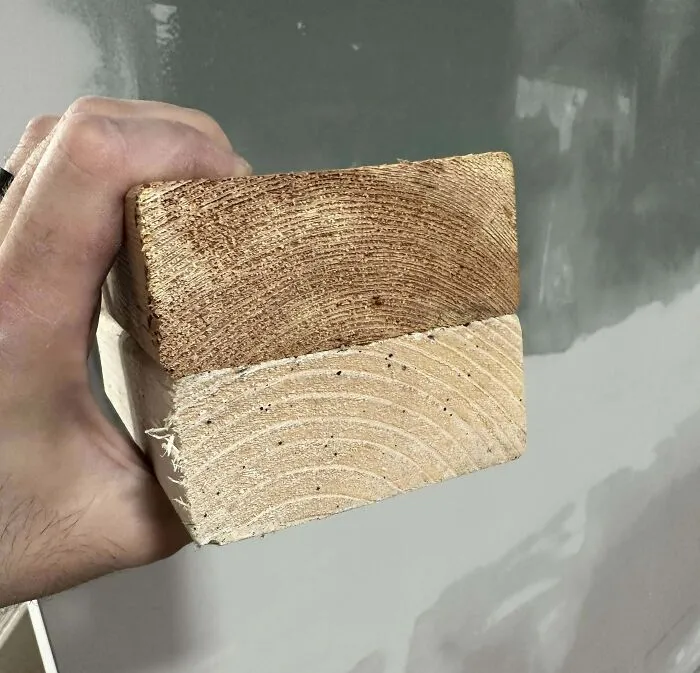 Hand holding a wooden block showing before and after photos of wood aging and color change over time.