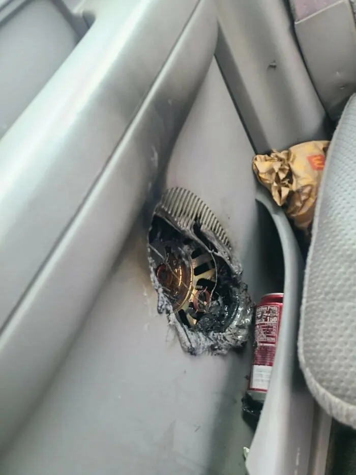 Burned car door panel with melted speaker and trash in the compartment showing an unexpected fail inside a vehicle.