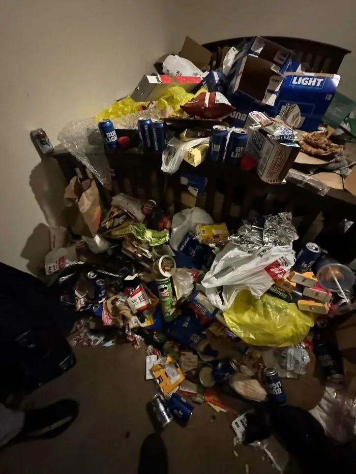 Pile of trash with empty cans, food wrappers, and bags creating an unfortunate unexpected fail in a cluttered room.