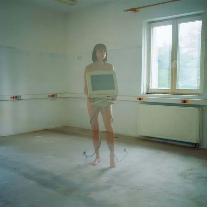 A photographer uses vintage cameras to capture intimate, cinematic-looking shots in a minimalistic room.