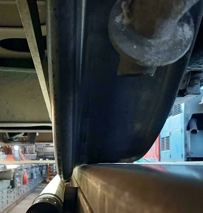 Rueda de tren en contacto con riel dentro de taller ferroviario, foto interesante que parece ilegal mirarla sin protección.