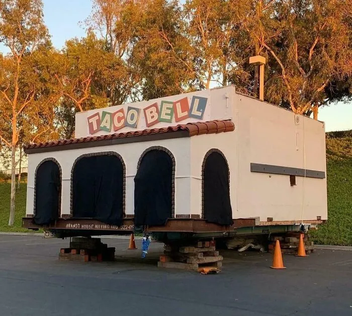 Pequeña antigua construcción de Taco Bell sobre estructura temporal, mostrando comparación increíble en perspectiva temporal.