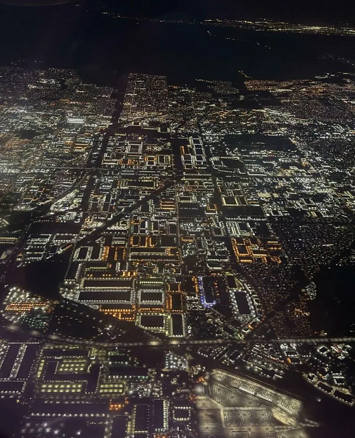 Vista aérea nocturna de una ciudad iluminada con luces brillantes en una foto interesante para SEO.