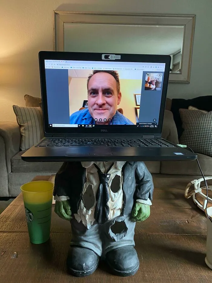 Laptop screen showing a man on video call placed on a gnome figure, illustrating funny work-from-home memes humor.